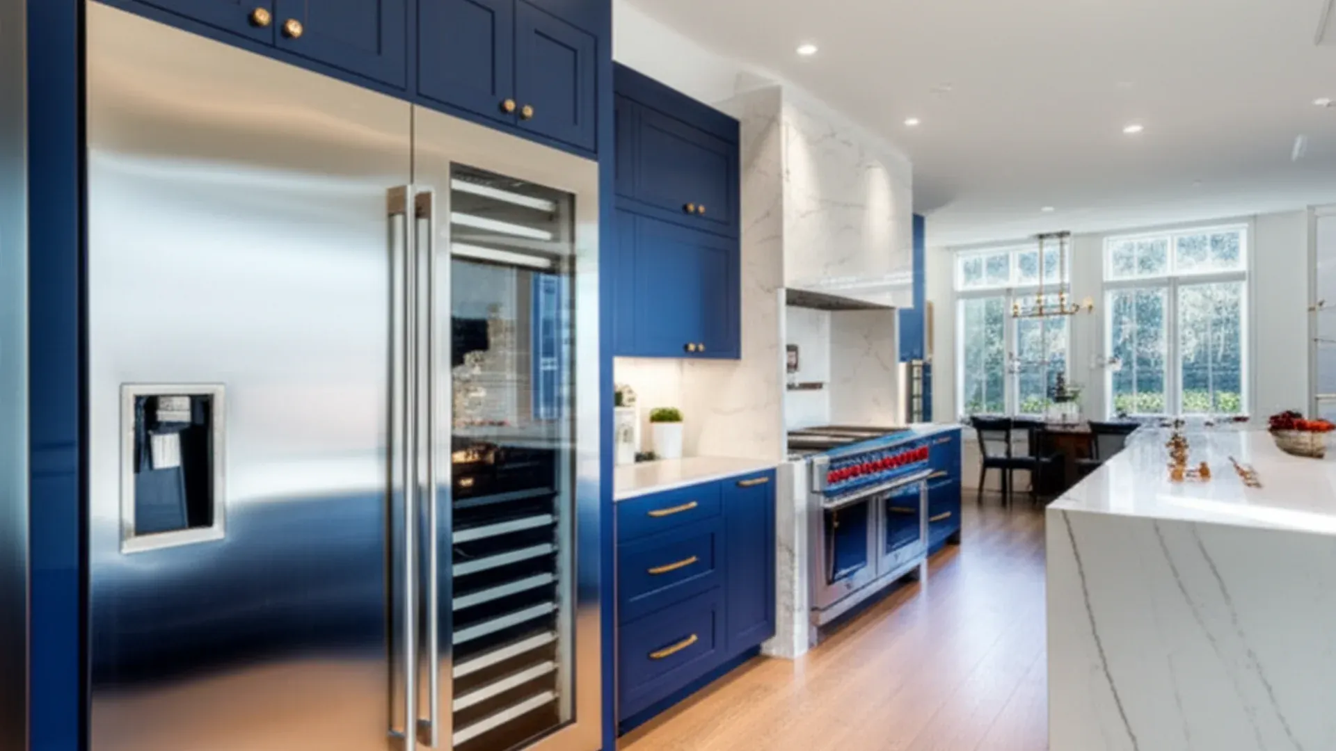 A tall stainless built-in refrigerator with a through-door dispenser set into navy-blue cabinetry, a glazed wine column beside it